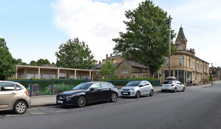An architect’s impression shows the unobtrusive new building in situ in Saltaire, a low, sleek contemporary building, with wooden detail and large glass windows.